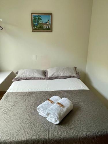 a bedroom with a bed with two towels on it at Hotel Vila Solar in Limeira