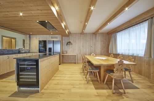 a kitchen with a large wooden table and chairs at Chalet Almglück by we rent, JOKERCARD INCLUDED in Saalbach-Hinterglemm
