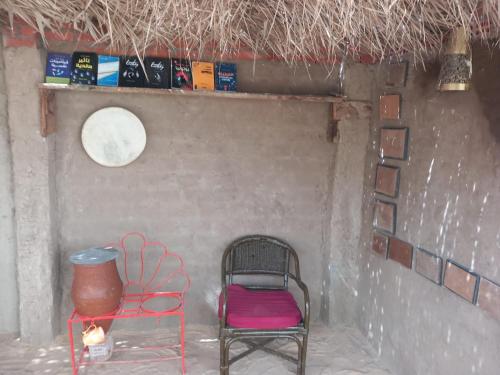 a chair and a vase sitting in a room at Soul House in Jazīrat Fīlah