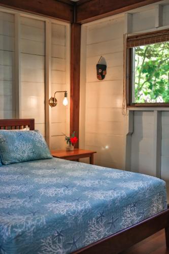 a bedroom with a bed and a window at The Lodge at Punta Rica- Hilltop Eco-Lodge with Views & Pool in Bastimentos