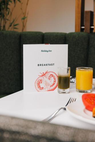 a table with a plate of food and two glasses of orange juice at Holiday Inn Newcastle South by IHG in Boldon