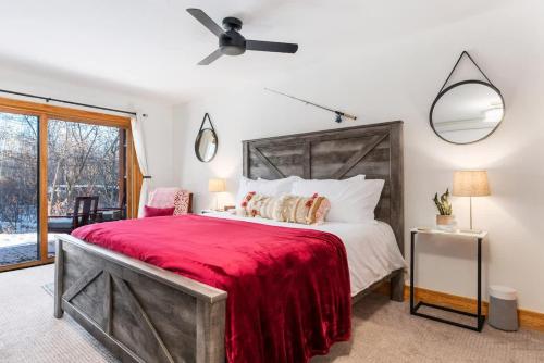 a bedroom with a large bed with a red blanket at Basecamp Stays: Upscale Getaway Shuttle Hot Tubs in Alta