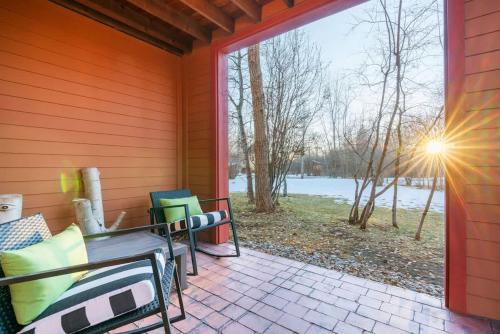 a screened porch with a table and chairs and a window at Basecamp Stays: Upscale Getaway Shuttle Hot Tubs in Driggs