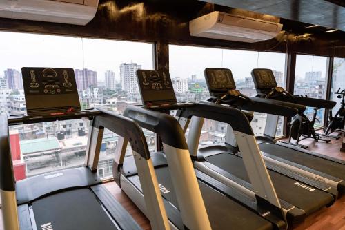 a gym with tread machines and a view of a city at Central Inn in Dhaka