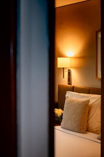 a bedroom with a bed with a pillow and a lamp at Hotel Dom Carlos Park in Lisbon