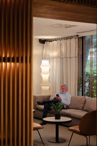 a man sitting on a couch in a living room at Hotel Dom Carlos Park in Lisbon