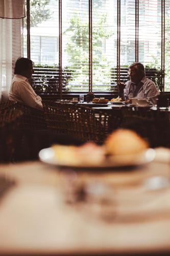 two people sitting at a table in a restaurant at Hotel Dom Carlos Park in Lisbon