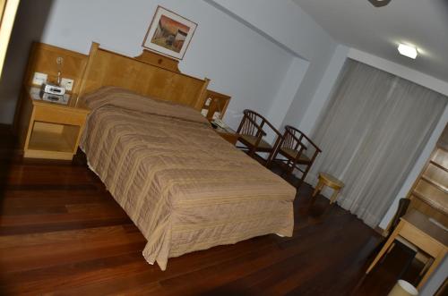 a bedroom with a bed and a table and chairs at Constantino Hotel e Eventos in Juiz de Fora