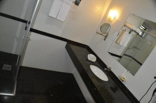 a bathroom with a sink and a mirror at Constantino Hotel e Eventos in Juiz de Fora