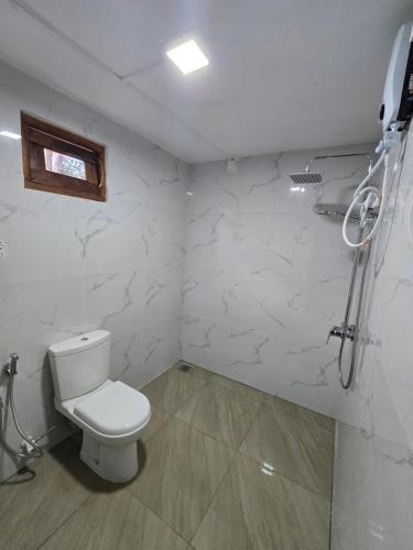 a bathroom with a toilet and a shower at Veenora Wild - Guest House in Anuradhapura