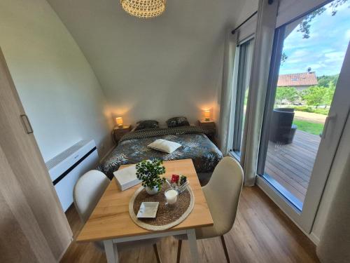 a small room with a bed and a table and a window at Domaine de la Tardoire in Oradour-sur-Vayres