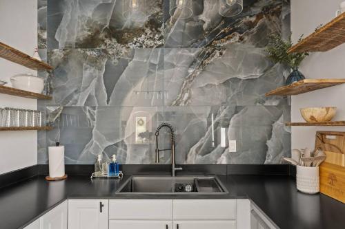 a kitchen with a sink and a marble wall at Historic 1914 Cottage in Reno