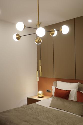 a bedroom with a bed with three lights above it at HOTEL METROPOL Club House in Yerevan