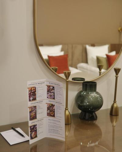 a table with a mirror and a vase on it at HOTEL METROPOL Club House in Yerevan
