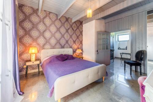 1 dormitorio con 1 cama con colcha púrpura en Côté cour, en Rasteau