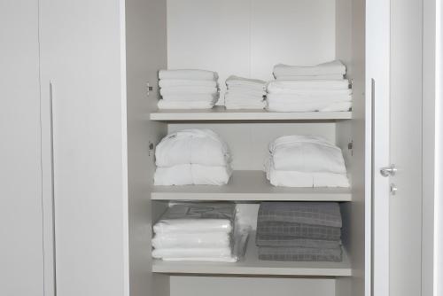 a closet with white towels and folded towels at Villa Eden in Castiglione di Sicilia