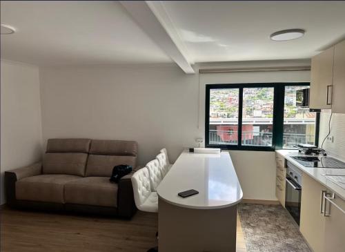a kitchen with a couch and a table in a room at Mocha House in Machico