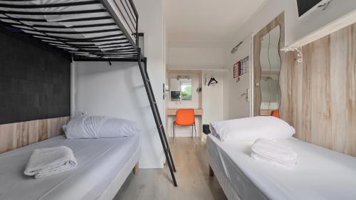 two bunk beds in a room with an orange chair at Fasthotel La Roche-sur-Yon in Mouilleron-le-Captif