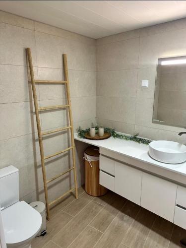 a bathroom with a sink and a toilet and a mirror at Mocha House in Machico