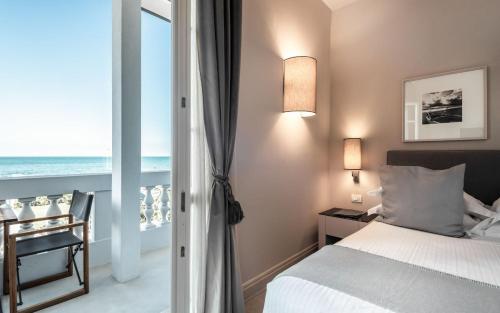 a bedroom with a bed and a view of the ocean at Villa Grey in Forte dei Marmi