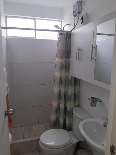 a bathroom with a toilet and a sink and a shower at Sol y Playa in Chiclayo