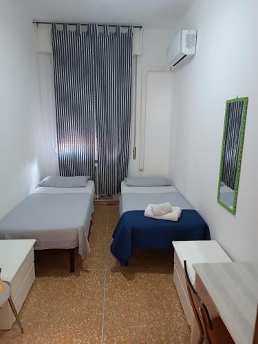 a room with two beds and a window at Affittacamere Pratello 97 in Bologna