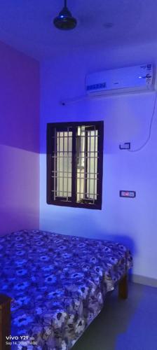 a blue room with a bed with a window at Vels Home Stay Temple View in Jāmb