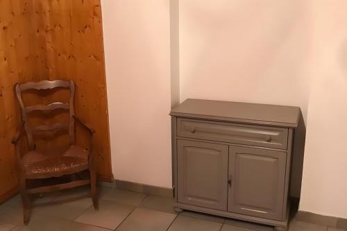 a chair and a wooden cabinet in a room at Appartamento In Chalet in Domène