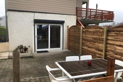 a patio with a wooden fence and a table and chairs at Appartamento In Chalet in Domène