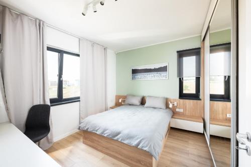 1 dormitorio con 1 cama y algunas ventanas en Aris Apartments - free parking - powered by NEO, en Dumbrăviţa