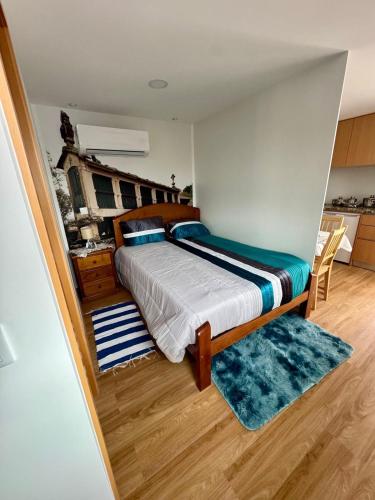 a bedroom with a large bed with a blue rug at Canastro do Loureiro in Anissó