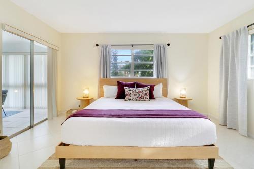 a bedroom with a large bed and a window at Steps To Beach! 4 Condos In 1- Perfect For Groups in West Palm Beach