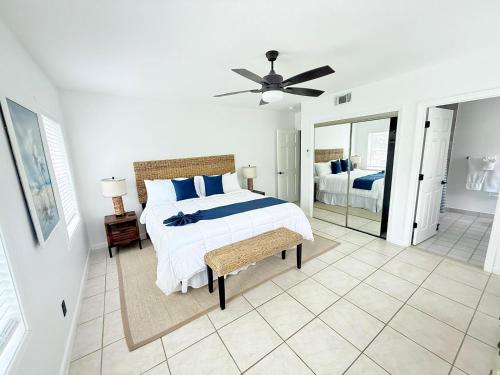 a white bedroom with a bed and a mirror at The Seagate in The Bight Settlements