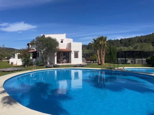 a large blue swimming pool in front of a house at Authentic Villa with amazing pool in Santa Gertrudis de Fruitera