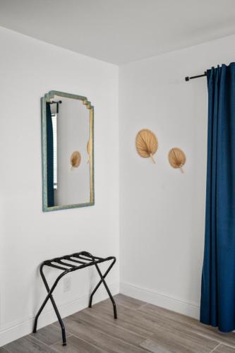 a mirror on a wall next to a chair in a room at Steps To Beach! 4 Condos In 1- Perfect For Groups in West Palm Beach