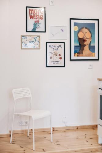 a white chair in a room with pictures on the wall at Einzigartiges Design Apartment in Löbau