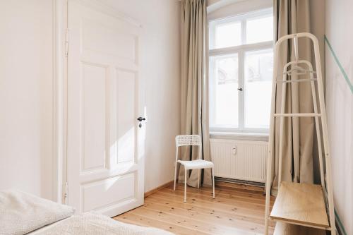 a bedroom with a door and a chair next to a window at Einzigartiges Design Apartment in Löbau