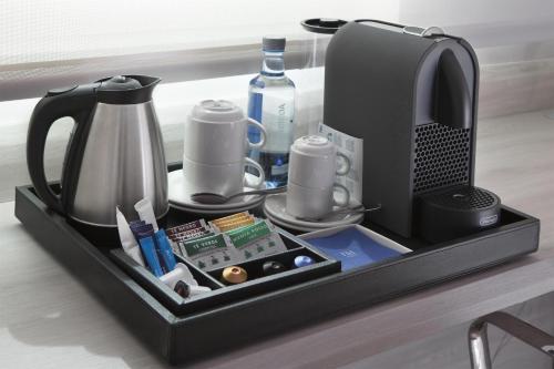 a tray with a coffee maker and other items on a table at NH Barajas Airport in Madrid