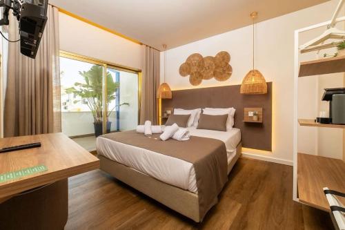 ザンブジェイラ・ド・マールにあるAlojamento Costa Alentejanaの大きなベッドと机のある寝室