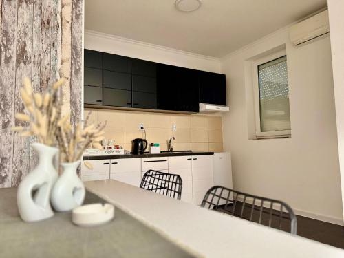 a kitchen with a counter and chairs in it at Stan na dan Moonlight Panonija in Inđija