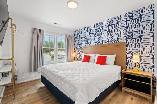 a bedroom with a large bed with red pillows at Pet Friendly Condo across from the beach in Myrtle Beach