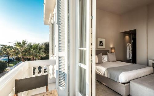 a bedroom with a bed and a balcony with a view at Villa Grey in Forte dei Marmi