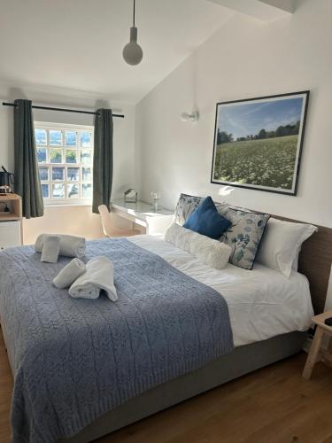 a bedroom with a large bed with a blue blanket at Redmire Village Pub in Redmire