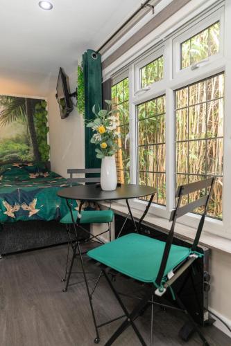 a room with a table and two chairs and a bed at Jungle Lodge in Rustington