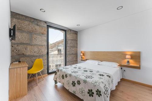 a bedroom with a bed and a large window at Sevenfarm Turismo Rural in Mangualde