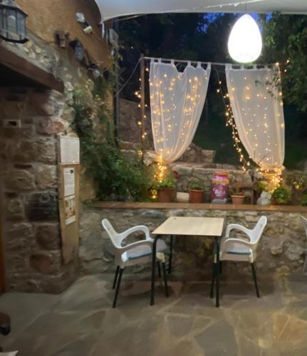 a table and chairs in a patio with lights at Casa Rural Molí de Fòrnols in Fornols