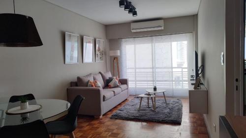 a living room with a couch and a table at Cálido y luminoso semipiso en Parque Chacabuco in Buenos Aires