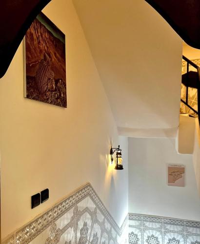 a staircase in a house with a painting on the wall at Riad Dar Sahara - Panoramic Rooftop in Nkob