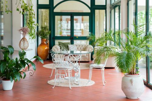a room with a table and chairs and plants at Hotel Castello Artemide Congressi in Castel San Pietro Terme