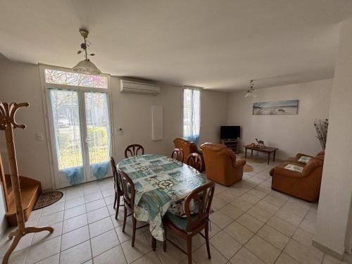 a living room with a table and chairs at Le bourg 2 in Mimizan